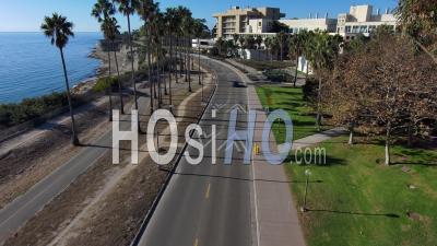 Aerial Of The University Of California Santa Barbara Ucsb College Campus, Along Road With Buildings And Palms Visible - Video Drone Footage