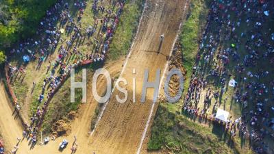 Aerial Of Motorcycle Rider On Vertical Dirt Incline Track At Motocross Event Travels Uphill To Finish Line - Video Drone Footage