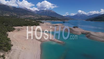 The Serre Ponçon Lake In Summer With A Very Low Level Due To Drought, Hautes-Alpes, France, Viewed From Drone