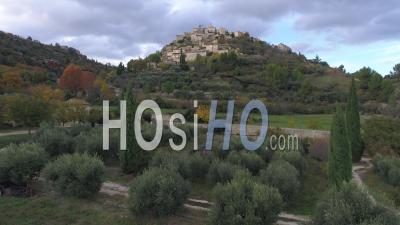 Village Of Gordes Perched On A Rocky Spur Dominated By Its Renaissance Castle And Its Romanesque Church Of Saint-Firmin, Vaucluse, France - Video Drone Footage