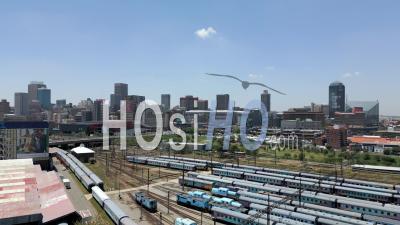 Braamfontein Train Yard With Johannesburg City Centre And The Metro Mall Taxi Rank In The Background - Video Drone Footage