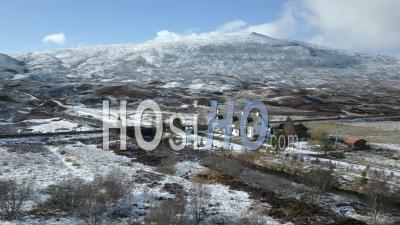 Petite Maison En Hiver Dans Les Highlands Écossais Pendant L'hiver Avec Des Montagnes Enneigées En Arrière-Plan - Vidéo Par Drone