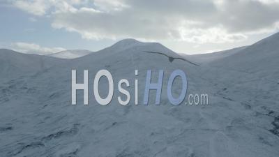 Snow-Capped Mountains During Winter Under Dappled Shade And Sun With The A9 Motorway In The Scottish Highlands - Video Drone Footage