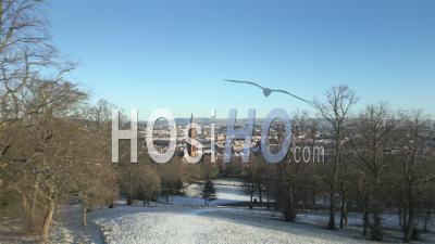 Queens Park And The Nearby Churches During A Winter Morning With Tenement Housing, The City Centre And The Campsies Mountains In The Background In Glasgow, Scotland - Video Drone Footage