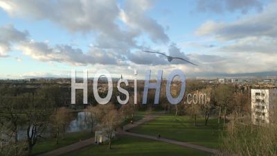 Queens Park And The Nearby Churches During A Spring Afternoon With Tenement Housing, The City Centre And The Campsies Mountains In The Background - Video Drone Footage