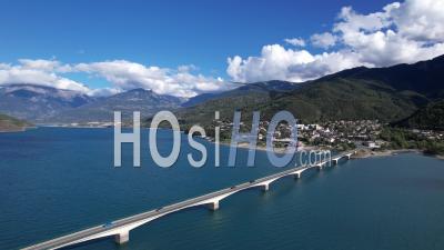 Bridge And Village Of Savines-Le-Lac On The Shore Of Lake Serre Poncon, Hautes-Alpes, France - Video Drone Footage