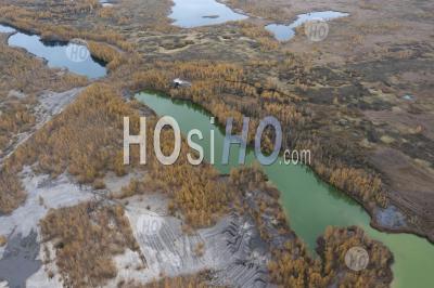 Vue Aérienne Des Arbres D'automne Et D'un Lac Avec De L'eau Verte Dans Une Carrière Abandonnée. - Photographie Aérienne