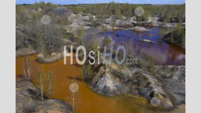 Aerial View Of Red, Yellow And Green Lakes Polluted Toxic Water In Nature. Against The Background Of Clay Hills In Abandoned Open Pit Mine. - Aerial Photography