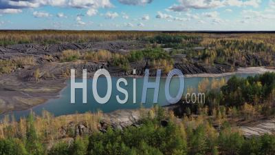 Voler Au-Dessus De La Carrière Abandonnée Avec Des Collines, Des Canyons Et Le Lac - Vidéo Prise Par Drone