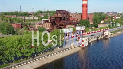 Flight Over Metallurgical Plant Near The Dam Across Rezh River. Movement Of Cars On Dam Across The River - Video Drone Footage
