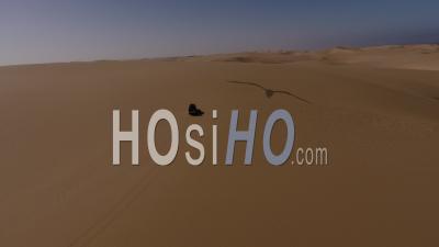 White Pick Up Driving On Sand Dune And Leaving Tracks In The Namib Desert, Followed By Drone, Aerial View